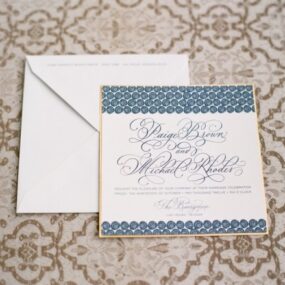 Hand Calligraphy Wedding Invitation Mounted on Gold Paper with Blue Swirls