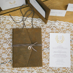 rustic barn wedding invitations with leather pocket and horseshoe charm